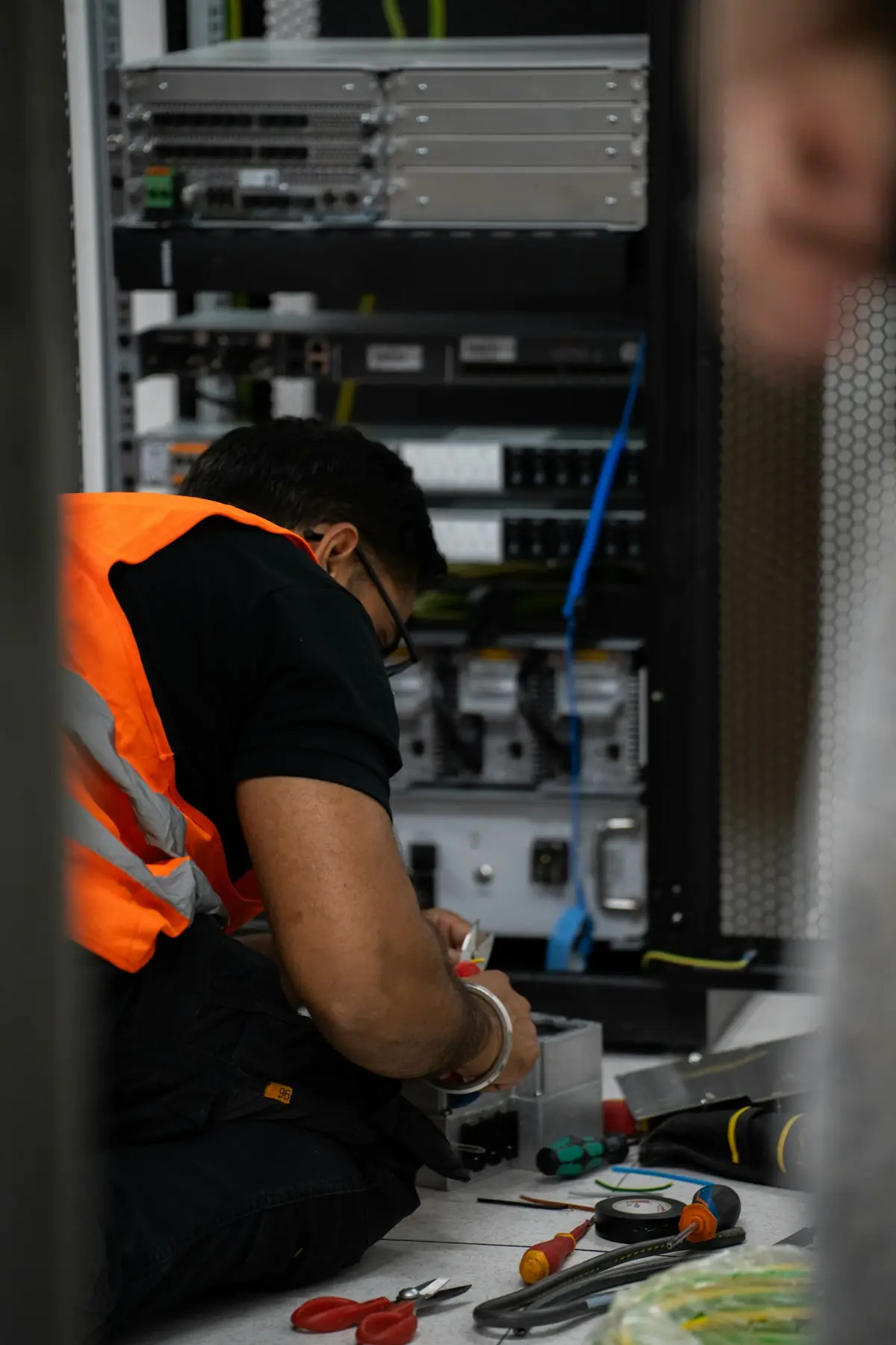 Técnico trabalhando em um rack de equipamentos de rede (imagem ilustrativa)
